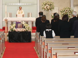 Funeral ceremony with a family praying in church